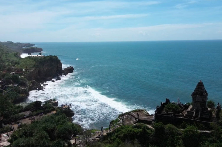Pulau Dewata Bali tentu memikat siapa saja yang mengunjunginya. Namun bagi yang sedang singgah di Yogyakarta juga bisa menikmati suasana pantai seperti di Bali lengkap dengan puranya. Namanya Pantai Ngobaran, di Kabupaten Gunungkidul.