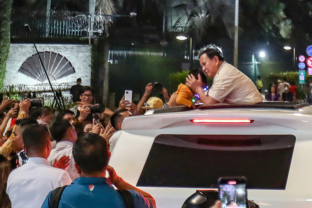 Presiden Prabowo Subianto menyapa masyarakat yang berkumpul di sepanjang jalan Sudirman-Thamrin, Jakarta, usai menghadiri Rapat Tutup Buku Tahunan bersama Menteri Keuangan Sri Mulyani, Selasa, 31 Desember 2024 malam.