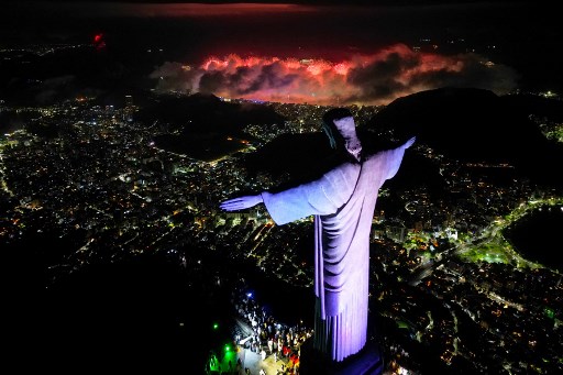 Pemandangan udara ini memperlihatkan patung Kristus Sang Penebus saat kembang api meledak di seluruh kota selama perayaan Tahun Baru di Rio de Janeiro pada awal 1 Januari 2025. AFP PHOTO/Mauro Pimentel