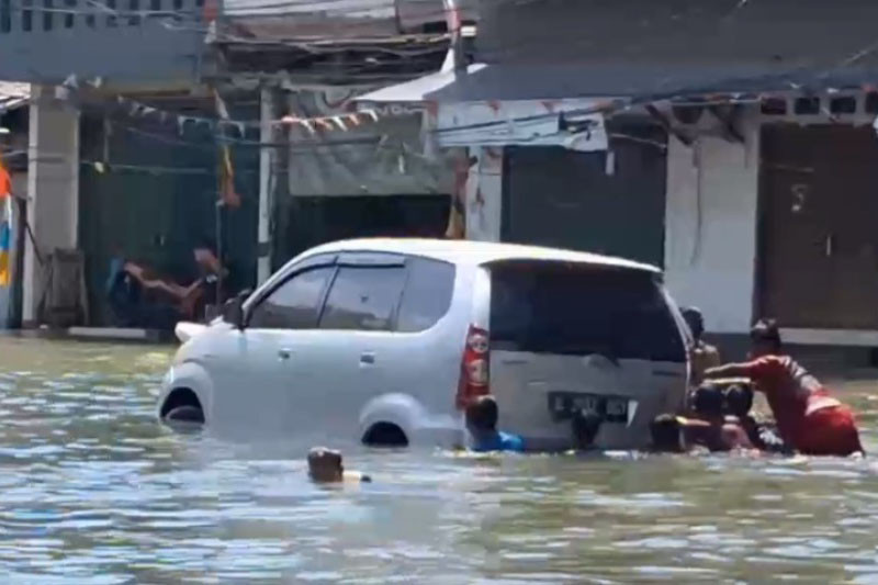 Selain itu, sebuah minibus yang nekat melintas dari arah Pelabuhan Kali Adem menuju ke luar kawasan Muara Angke juga mengalami mogok hingga harus didorong oleh anak-anak yang sedang bermain banjir.