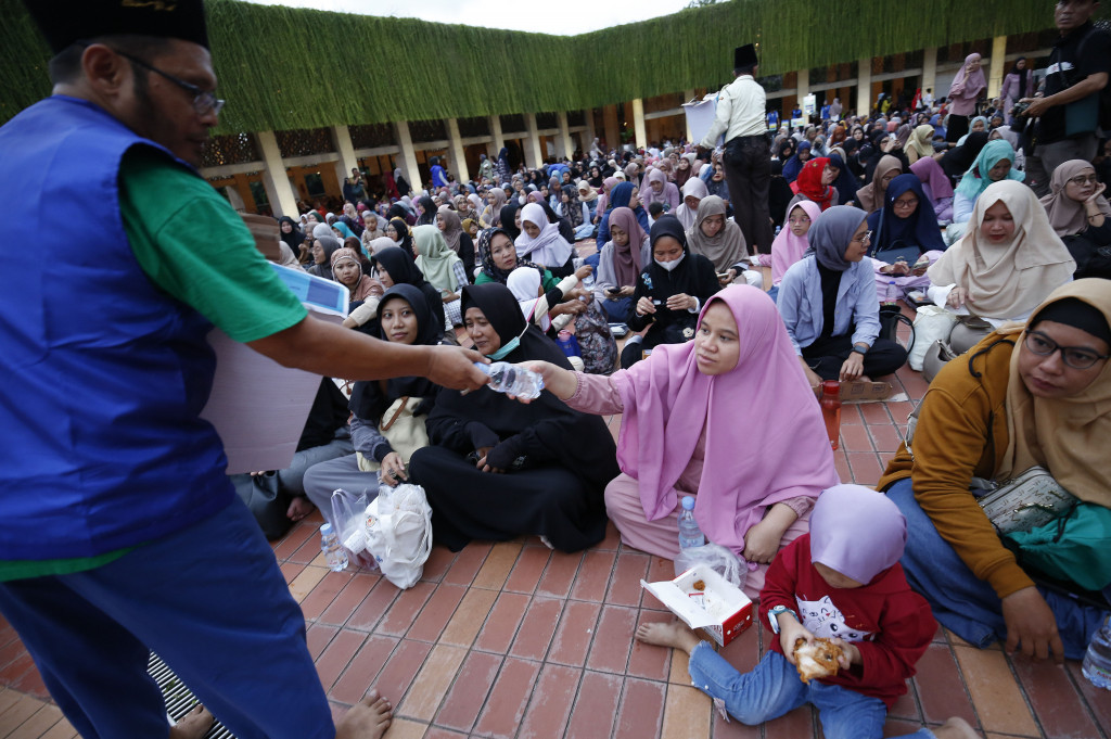 Masyarakat berbaris antri menunggu menu makanan saat berbuka puasa bersama di Masjid Istiqlal, Jakarta, Minggu, 2 Maret 2025. 
