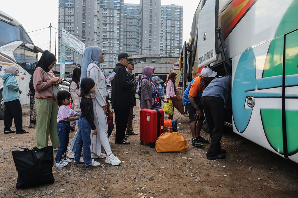 Pemudik tujuan Jawa Tengah antre memasukkan barang bawaan ke dalam bagasi bus yang akan ditumpanginya di Terminal Bayangan Pasar Cipulir, Jakarta Selatan, Rabu, 25 Maret 2025.
