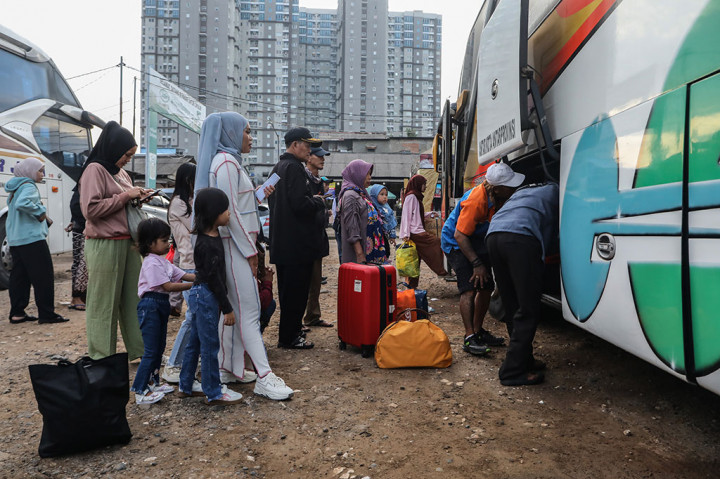 Pemudik tujuan Jawa Tengah antre memasukkan barang bawaan ke dalam bagasi bus yang akan ditumpanginya di Terminal Bayangan Pasar Cipulir, Jakarta Selatan, Rabu, 25 Maret 2025.