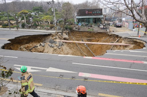 Sebuah sinkhole muncul di luar toko tanaman di jalan di Seoul pada Selasa, 25 Maret 2025. Seorang pengendara sepeda motor tewas setelah terperosok ke dalam lubang pembuangan (sinkhole) sedalam 20 meter (65,62 kaki) di ibu kota Korea Selatan. 