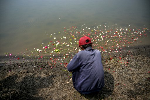 Mereka datang sambil membawa bunga. Di atas tanggul lumpur, mereka kemudian memanjatkan doa dan tabur bunga.