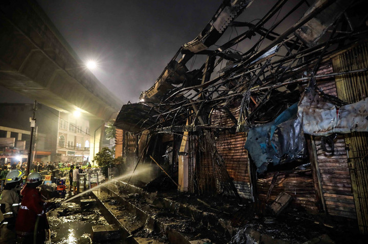 Petugas pemadam kebakaran melakukan pendingin api yang menghanguskan kios-kios di Pasar Taman Puring, Jakarta Selatan, Senin, 28 Juli 2025 malam. 