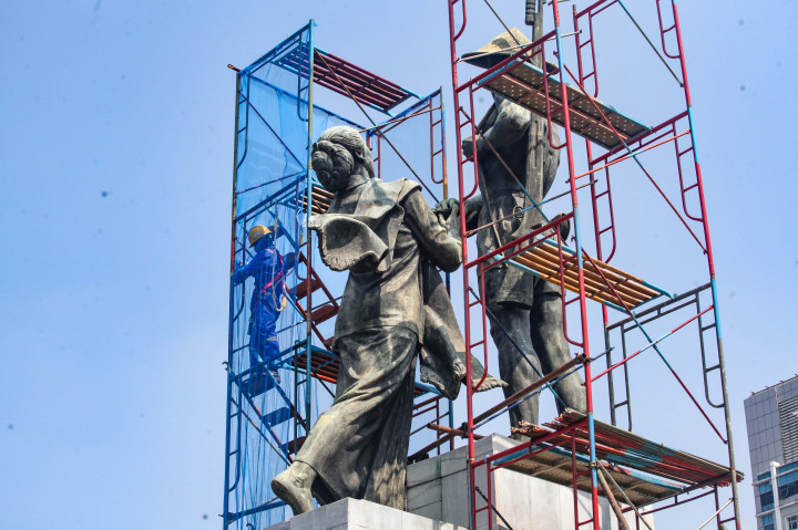 Pekerja memasang kontruksi untuk melakuan perawatan berkala pada patung Tugu Tani di Menteng, Jakarta Pusat, Selasa, 26 Agustus 2025. 
