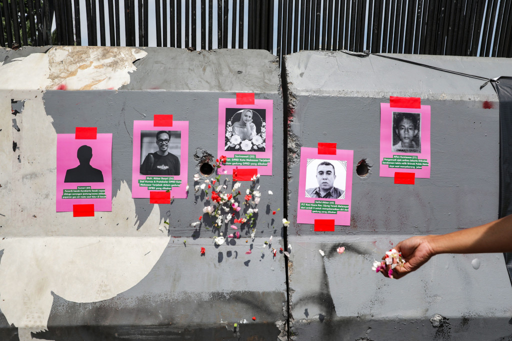 Dengan mengenakan pakaian berwarna pink mereka membentangkan poster yang berisi tuntutan dan menabur bunga pada poster korban meninggal dunia akibat unjuk rasa saat berunjuk rasa di depan Gedung DPR Senayan, Jakarta, Rabu, 3 September 2025. 