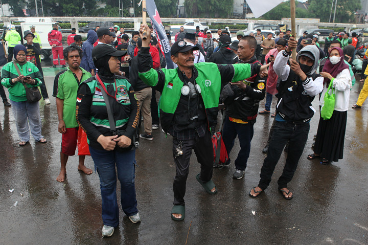 Puluhan pengemudi ojek daring/online (ojol) menerobos hujan deras untuk berunjuk rasa di depan Gedung DPR/MPR untuk menyampaikan sejumlah aspirasi seperti potongan komisi di aplikasi maksimal 10 persen.