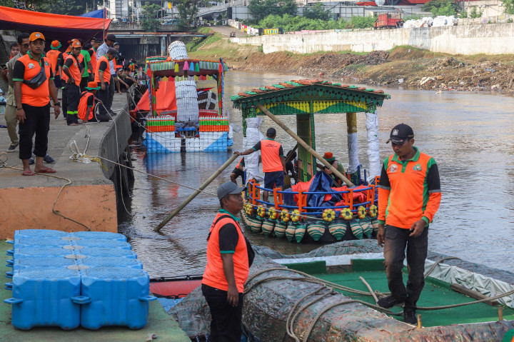 Petugas UPS Badan Air Dinas Lingkungan Hidup DKI Jakarta menghias perahu limbah botol plastik saat persiapan menjelang Festival Cinta Lingkungan di Kali Ciliwung, Cawang, Jakarta Selatan, Selasa, 23 September 2025. 