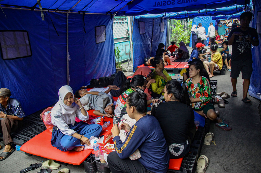 Beberapa warga lainnya pasrah dan beristirahat di tenda pengungsian.