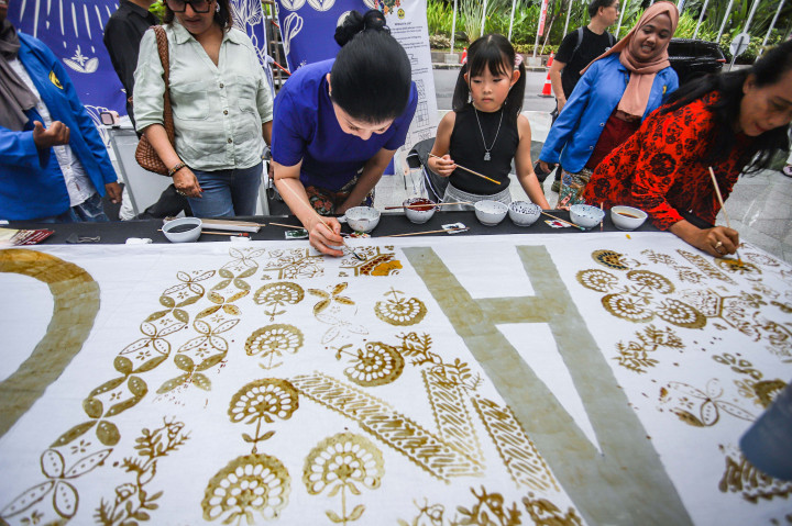 Sejumlah warga menggambar motif batik di atas kain putih saat kegiatan membatik asyik dalam rangka Hari Batik Nasional di Jakarta, Kamis, 2 Oktober 2025. 
