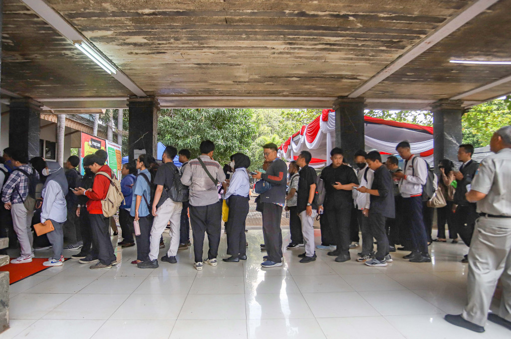 Para pencari kerja antre untuk memilih lowongan kerja pada sejumlah perusahaan di Jakarta Job Fair 2025 di Gelora Sunter, Jakarta Utara, Selasa, 14 Oktober 2025.