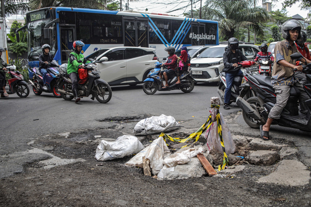  Pengendara melintasi jalan yang rusak di Jalan Gedong Panjang, Penjaringan, Jakarta Utara, Selasa, 3 Februari 2026. 