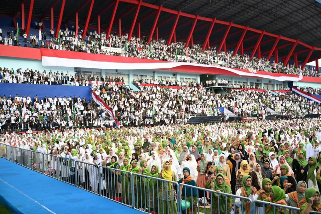 Disambut ratusan ribu jemaah NU yang telah memadati stadion sejak malam hari, Presiden tampak menyapa peserta dan mengapresiasi suasana khidmat yang tercipta. 