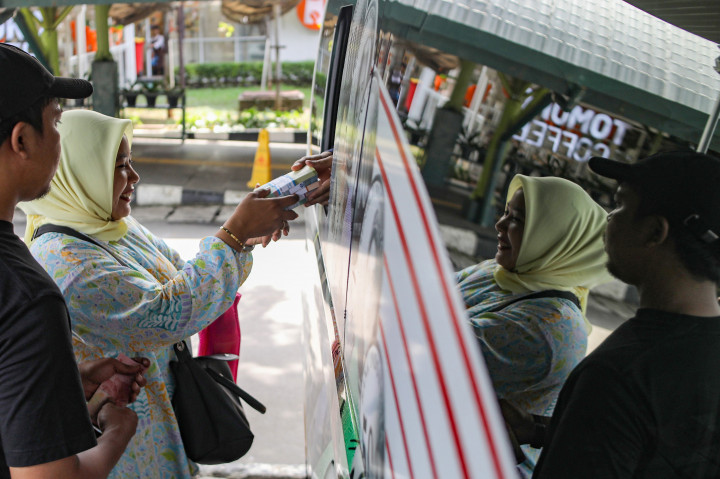 Warga antre untuk menukarkan uang baru yang disediakan oleh Bank Indonesia di area parkir Stasiun Gambir, Jakarta, Senin, 16 Maret 2026. 

