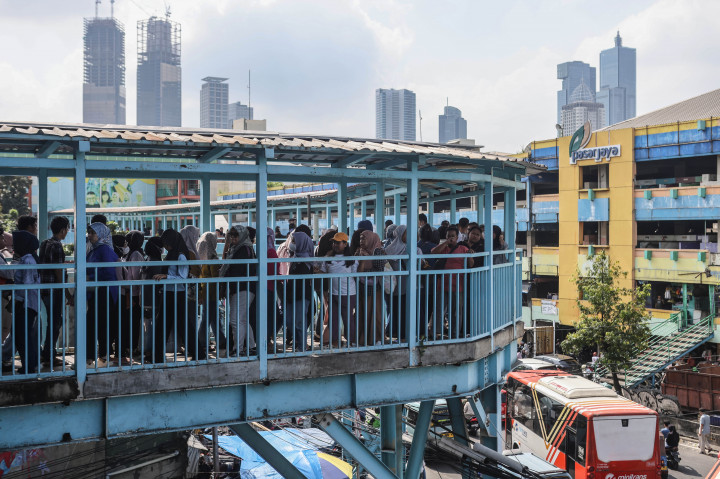Warga memenuhi skybridge yang menghubungkan Stasiun Tanah Abang dengan Pasar Tanah Abang, Jakarta, Minggu, 15 Maret 2026.