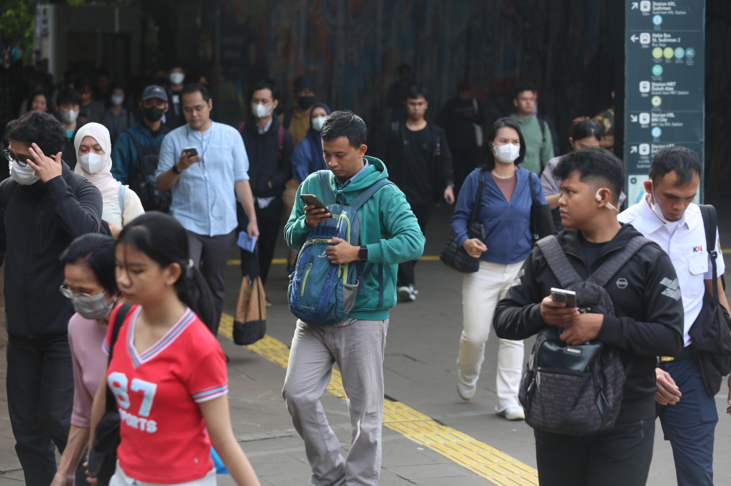 Pekerja Turun dari kereta Commuter Line melewati trotoar menuju lokasi kantor mereka di kawasan Dukuh Atas, Jakarta, Rabu, 25 Maret 2026.
