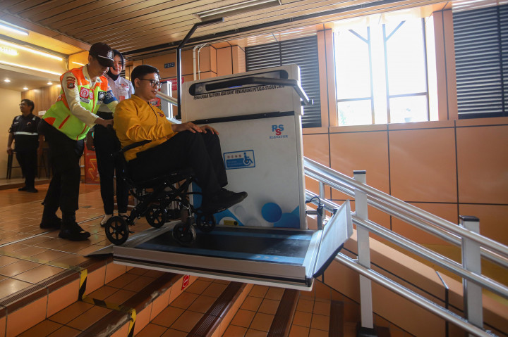 Seorang penyandang disabilitas menggunakan fasilitas platform lift dengan pengawasan petugas di Stasiun Cikini, Jakarta, Senin, 30 Maret 2026. 