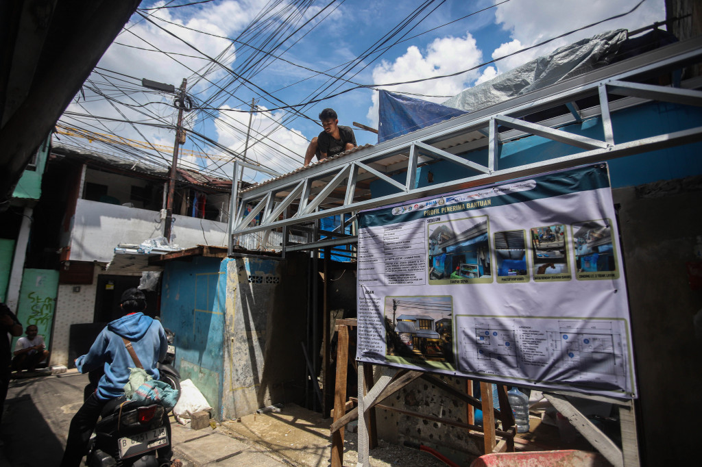 Pekerja menggarap renovasi rumah warga pada Program Kampung Gotong Royong di kawasan kumuh Menteng Tenggulun, Jakarta Pusat, Minggu, 5 April 2026