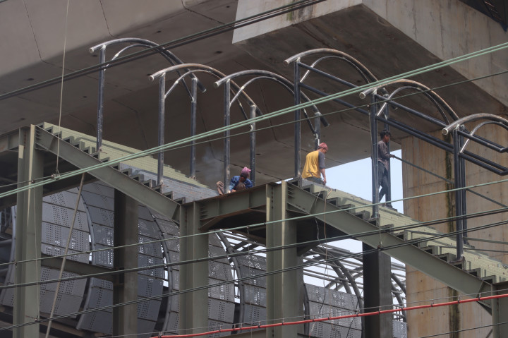 Pekerja menyelesaikan proyek pembangunan Jembatan Penyeberangan Orang (JPO) di kawasan Jakarta International Stadium (JIS), Jakarta Utara, Rabu, 8 April 2026.