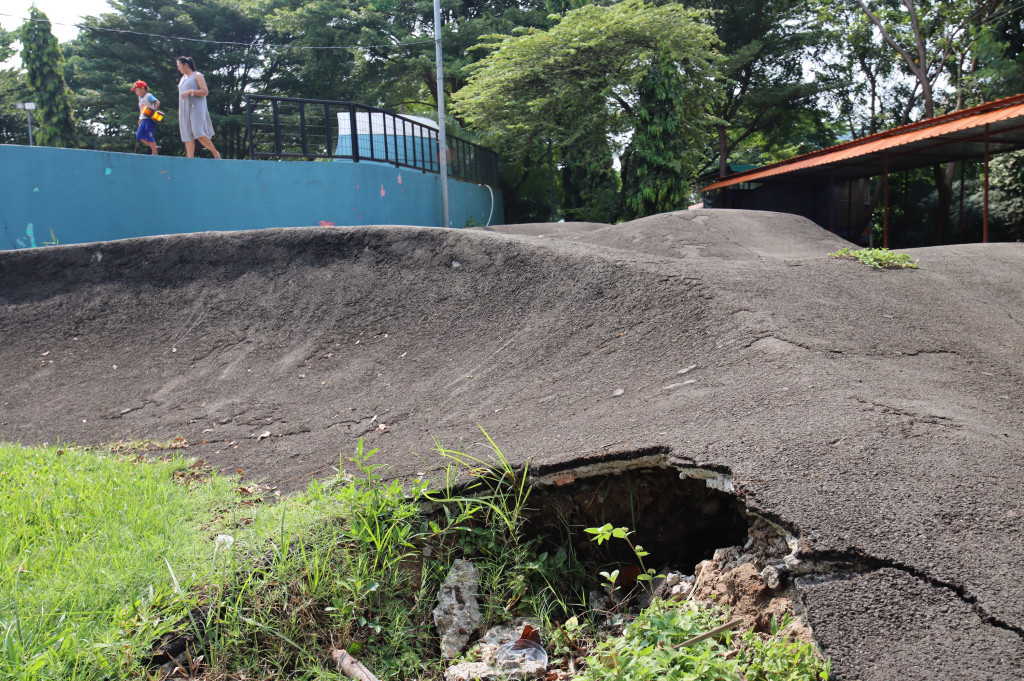 Aspal trek sepatu roda yang retak hingga berlubang di beberapa sisi. 