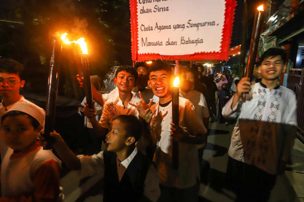 Anak-anak membawa obor saat mengikuti pawai menyambut Tahun Baru Islam 1 Muharam 1448 Hijriah di Menteng Jaya, Jakarta Pusat, Senin, 15 Juni 2026.
