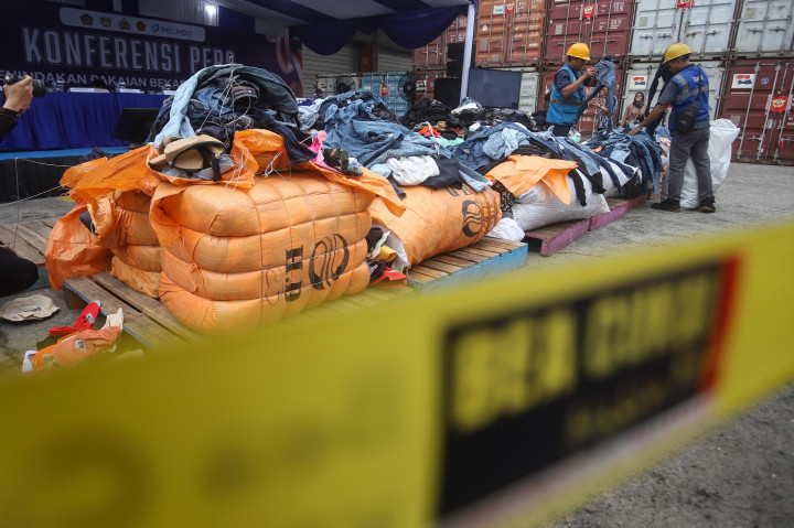 Petugas menata barang bukti pakaian bekas sebelum konferensi pers penindakan peti kemas pakaian bekas impor ilegal di Buffer Area TPS CDC Pelabuhan Tanjung Priok, Jakarta, Selasa, 23 Juni 2026.
