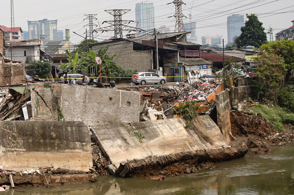 Warga menyaksikan dinding turap yang ambrol di tepi Kanal Banjir Barat, Bendungan Hilir, Jakarta Pusat, Jumat, 26 Juni 2026.
