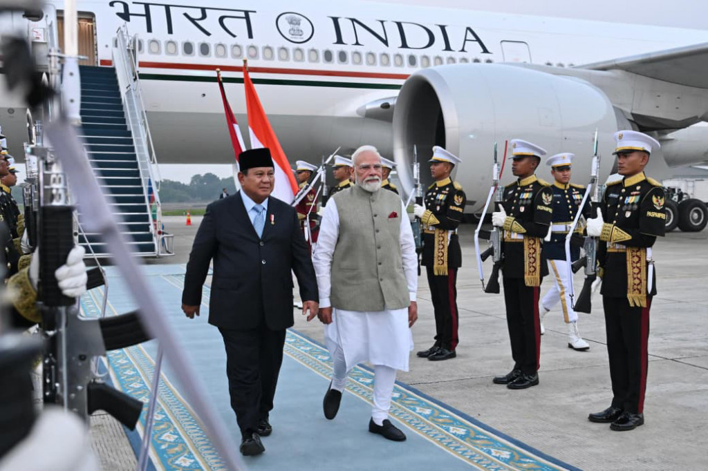 Penyambutan Presiden Prabowo secara langsung di bawah tangga pesawat menunjukkan penghormatan kenegaraan yang memperlihatkan kedekatan dan rasa hormat Indonesia kepada India. Di bawah tangga pesawat, kedua pemimpin saling berjabat tangan dan berbincang sambil saling melempar senyum hangat.