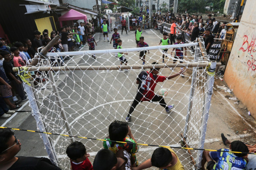 Anak-anak mengikuti turnamen sepak bola jalanan yang dikenal dengan sebutan 'Liga Aspal' di sepanjang jalur rel kereta api di Jakarta, Sabtu, 27 Juni 2026.
