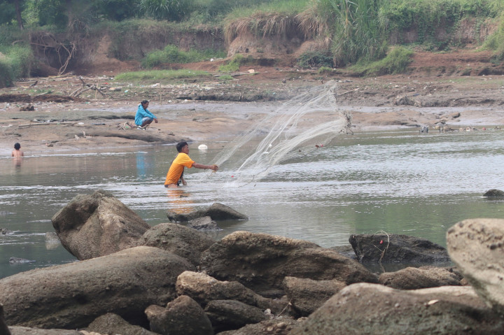 Sejumlah warga memanfaatkan aliran Sungai Cisadane yang mengering untuk mencari ikan di kawasan Pintu Air 10 Sungai Cisadane,Tangerang, Banten, Rabu, 22 Juli 2026. 
