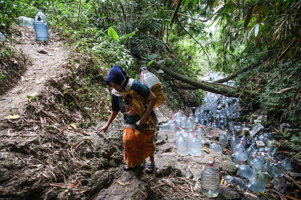 Setiap harinya, warga rela menempuh perjalanan turun dan menanjak sekitar satu hingga dua kilometer dan melewati jalan setapak, menuruni bebatuan menuju kawasan hutan tempat sumber mata air berada.