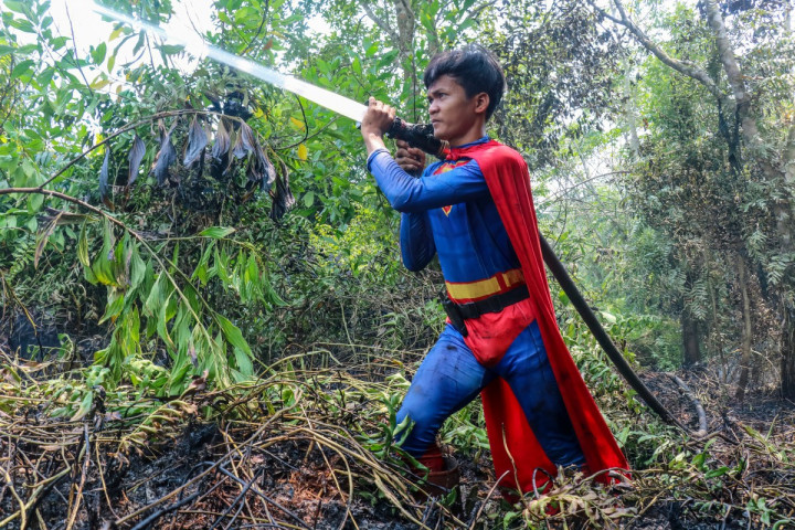 Remaja bernama Rudiansyah, mengenakan kostum Superman saat membantu memadamkan kebakaran hutan dan lahan (karhutla) di Petuk Katimpun, Palangkaraya, Kalimantan Tengah, Senin, 17 Agustus 2026.