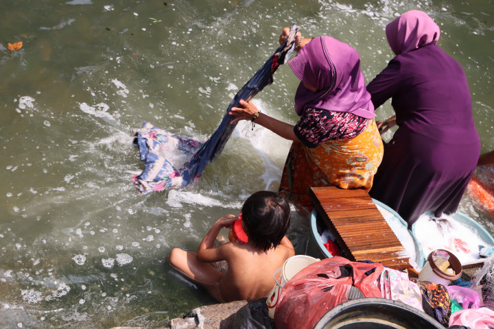 Sejumlah warga memanfaatkan aliran Sungai Cisadane untuk mencuci pakaian, sementara anak-anak bermain air di Selapajang Jaya, Kota Tangerang, Banten, Minggu, 6 September 20