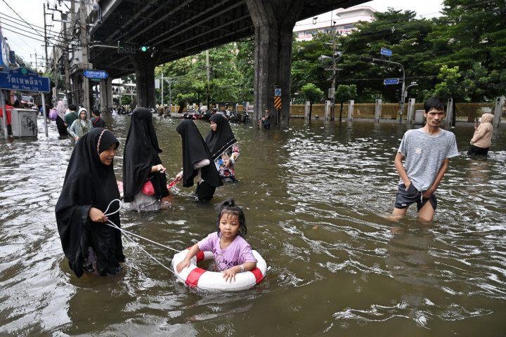 Warga menerobos genangan banjir di kawasan Ramkhamhaeng, Bangkok, Thailand, Minggu, 27 September 2026.