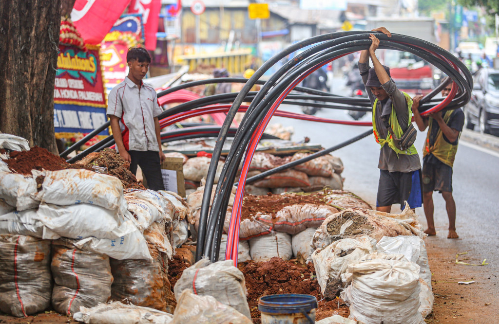 Para pekerja mengerjakan proyek penataan utilitas bawah tanah yang berbarengan dengan revitalisasi trotoar di kawasan Palmerah, Jakarta, Jumat, 23 Oktober 2026. 