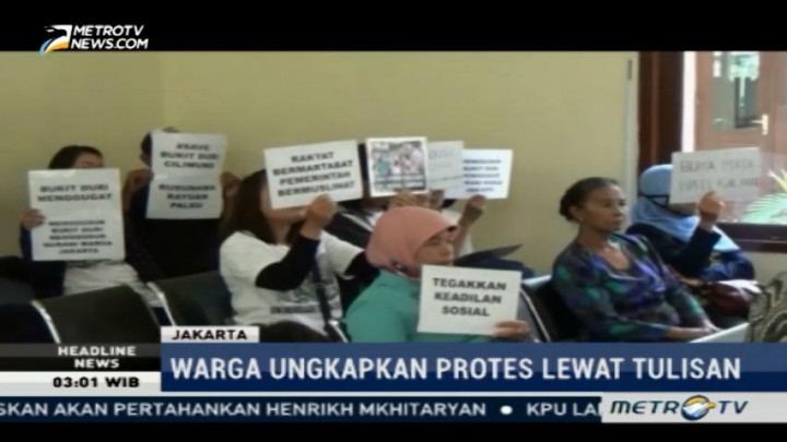 Warga Bukit Duri Bawa Poster Penolakan Penggusuran saat Sidang