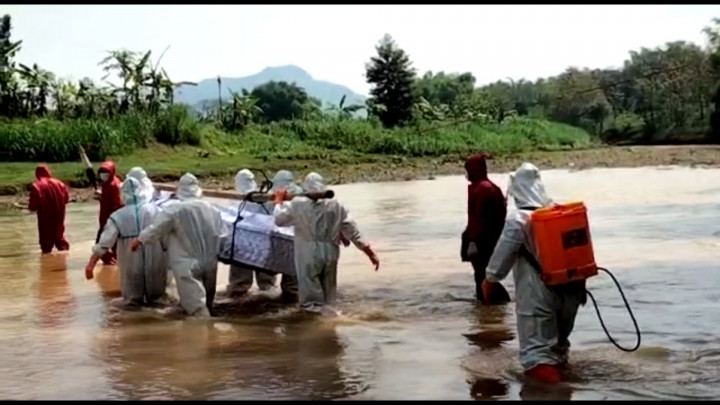 Makamkan Pasien COVID-19, Petugas Medis Sebrangi Sungai Sambil Panggul Jenazah