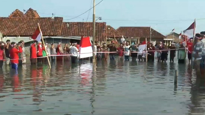 Warga Demak Kibarkan Merah Putih di Tengah Banjir Rob