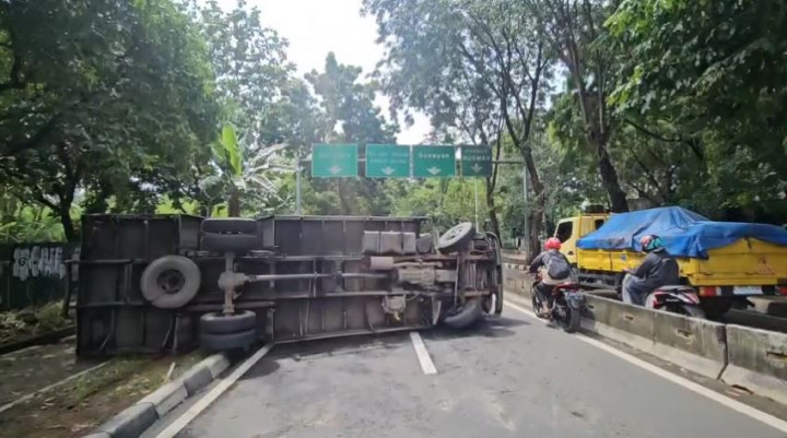 Truk Bermuatan Pipa Terguling di Jalan Grogol Utara