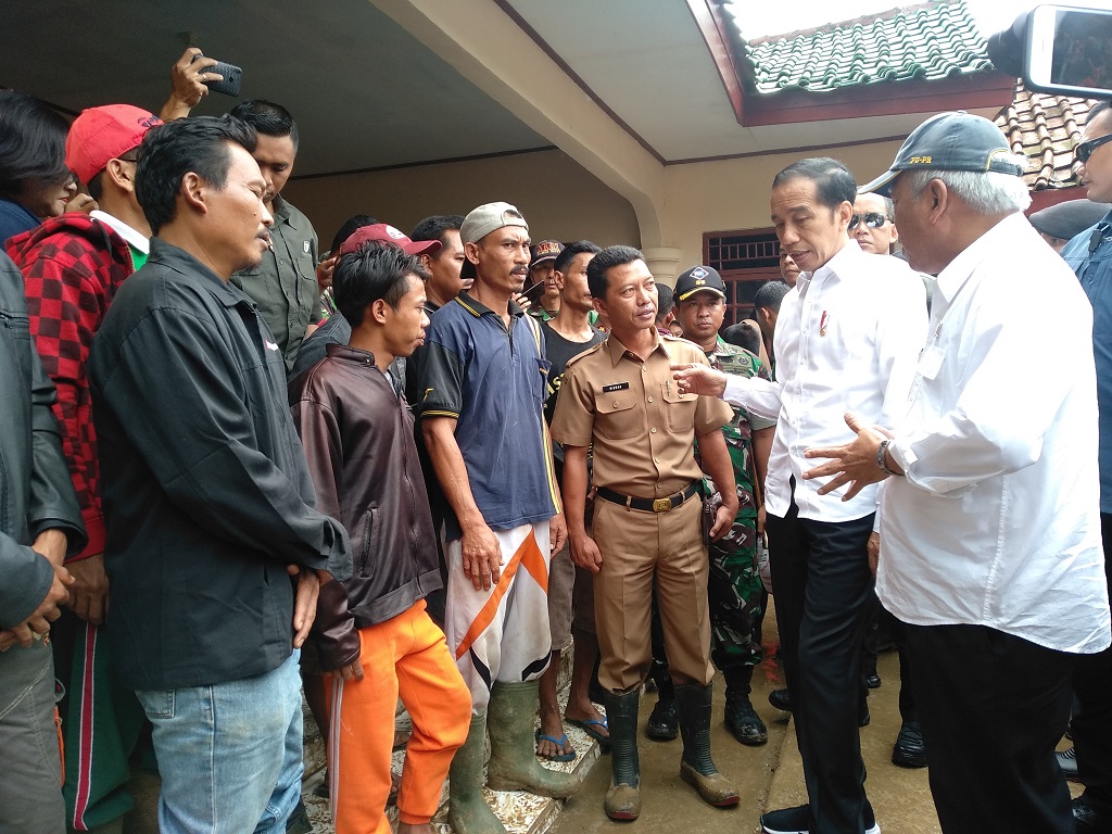 Gunakan Ponco, Jokowi Tinjau Desa Terisolasi di Sukajaya