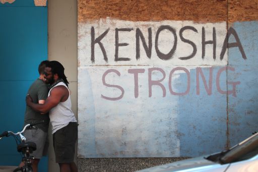 Warga AS berpelukan saling memberi semangat dalam protes di Kenosha. Foto: AFP.
