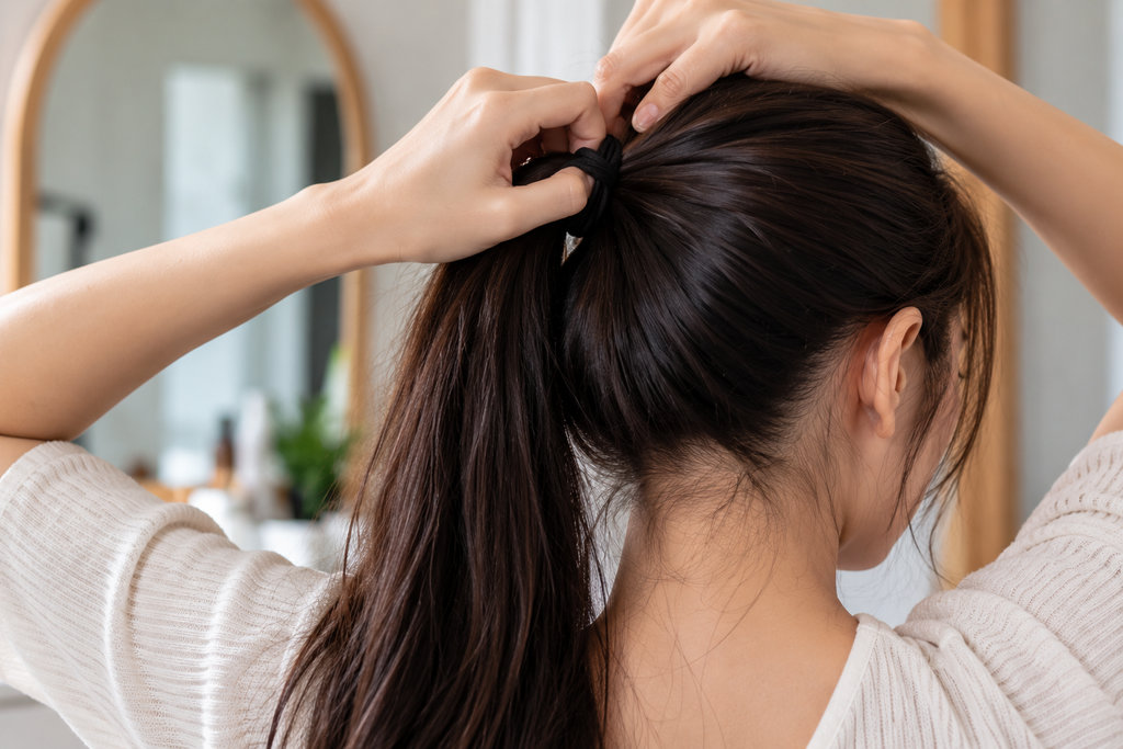 Mengikat Rambut di Kamar Bernuansa Hangat
