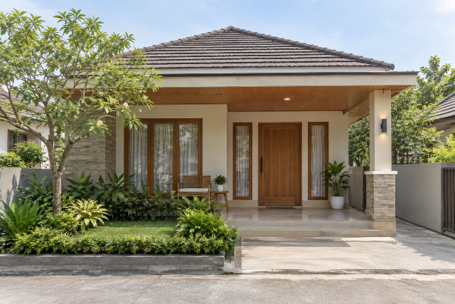 Desain teras rumah kampung dengan taman hijau
