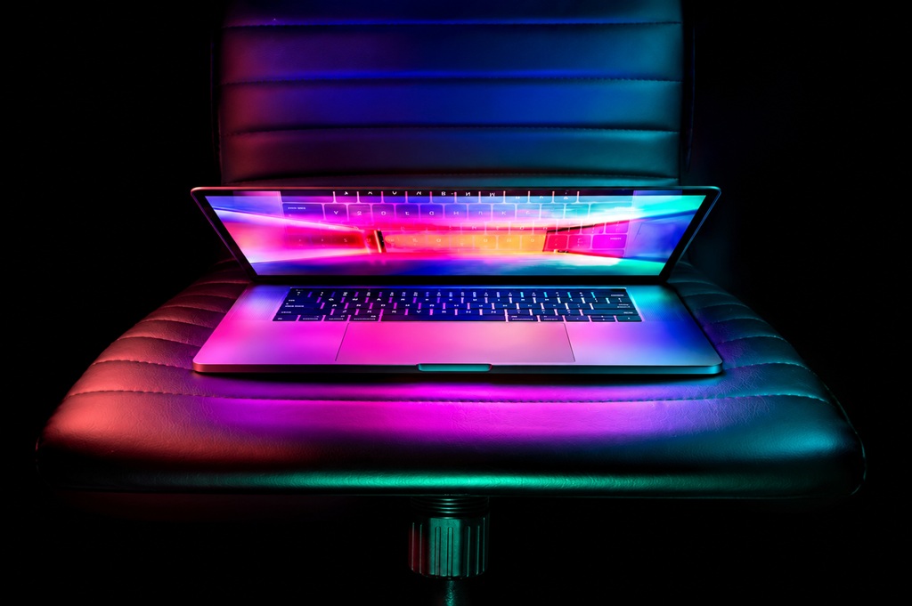 Neon MacBook Pro on Leather Chair